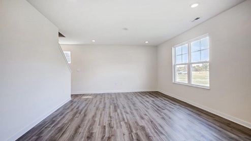 great room with tucked staircase and double window