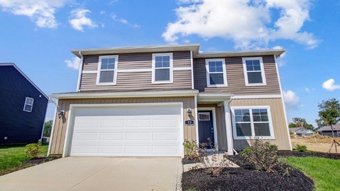 two story home with tan siding, covered entry, two car garage