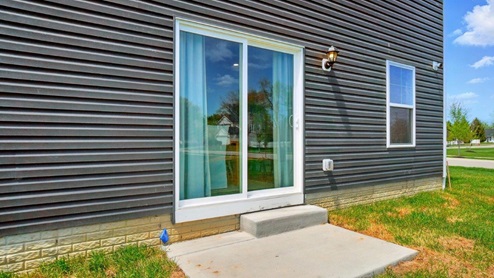 rear exterior of home featuring a concrete patio and spacious backyard