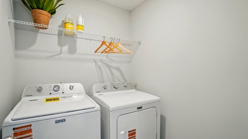 spacious laundry room featuring side by side washer and dryer and built in shelves