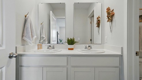 bathroom featuring dual vanity sinks with mirror above each sink