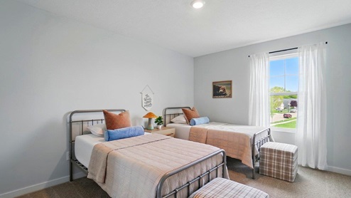 bedroom featuring 2 twin beds with orange bedding and a window