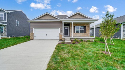 single story home with tan siding, partial stone front, two car garage
