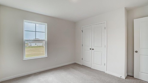 third bedroom with single window and closet