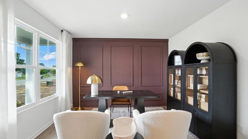 flex office space with desk, chairs and book shelves