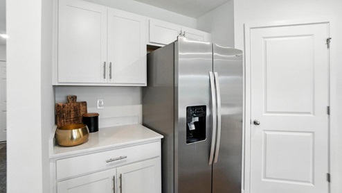 white cabinets, fridge, walk in corner pantry