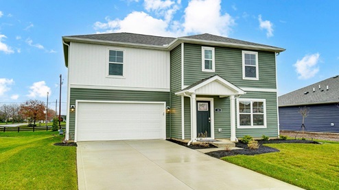 two story home with white and green siding, covered entry and two car garage_angle