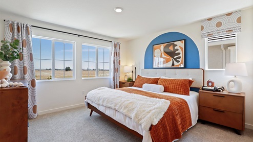 Spacious bedroom with two paned window and floor length curtains.