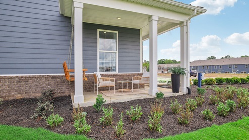 Two story new townhome end unit view of outside exterior with porch swing