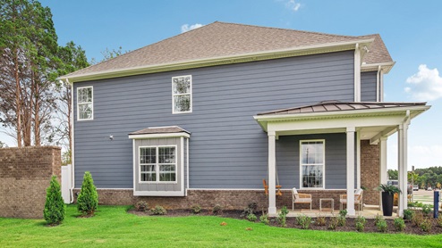 Two story new townhome end unit view of outside exterior with porch swing