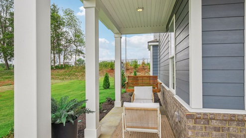 Two story new townhome end unit view of outside exterior with porch swing