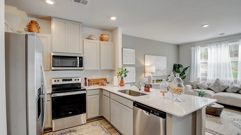 Open-concept kitchen with new cabinets and quartz countertops.