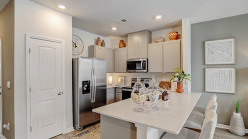Open-concept kitchen with new cabinets and quartz countertops.