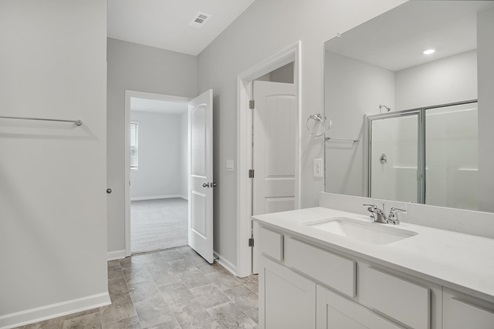 Bathroom with step in shower with glass doors.