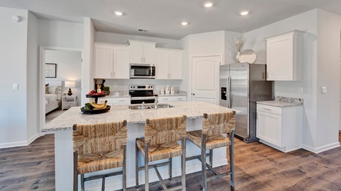 Beautiful kitchen area with light cabinets and stainless steel appliances