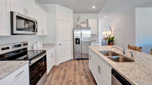 Kitchen area with a corner walk in pantry that is spacious