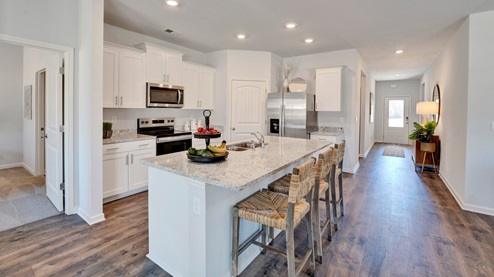 located at the end of the entry hall, the beautiful kitchen opens up to the main living areas of the home