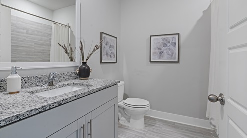 third full bathroom with single vanity, granite counter, and shower/tub
