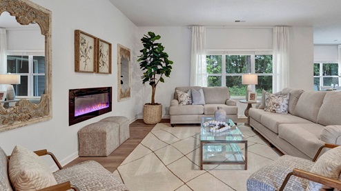 living room with electric fireplace, light neutral paint on the walls and windows allowing in natural light