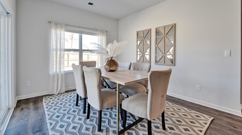 DIning area with a large double window overlooking the backyard