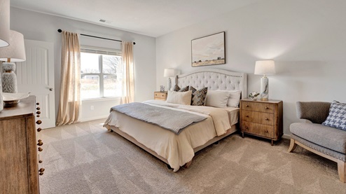 Primary bedroom with a large double window overlooking the backyard