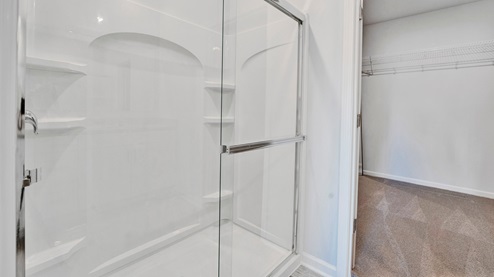 En suite primary bathroom with a glass enclosed walk in shower