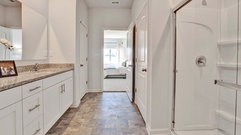 En suite primary bathroom with granite countertops