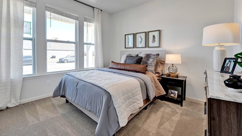 Secondary bedroom sitting at the front of the house with large windows overlooking the front yard