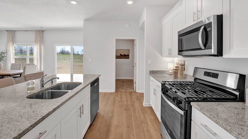 Kitchen area with light cabinets and stainless steel appliances
