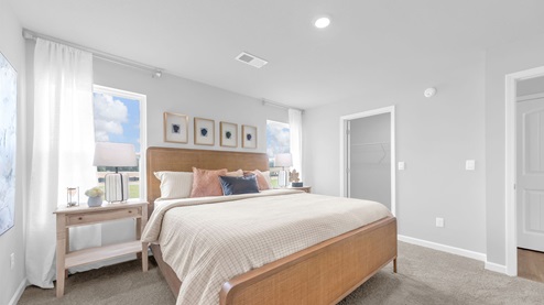 Primary bedroom with an en suite walk in spacious closet with ventilated shelving