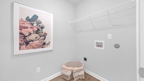 Laundry room at the front of the home with ventilated shelving for extra storage