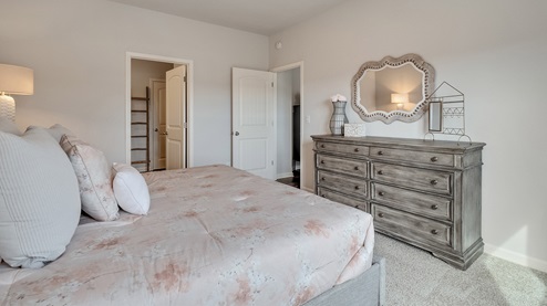 Primary bedroom comfortably fits a king size bed and additional bedroom furniture