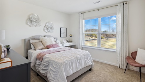 Guest bedroom with double window and carpet