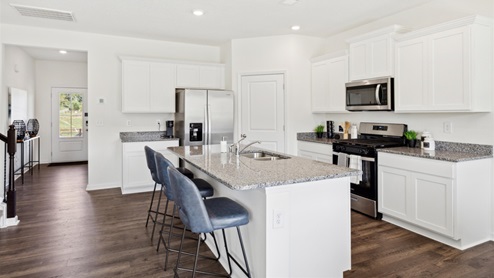 Kitchen with white, shaker-style cabinetry, granite countertops, and stainless-steel appliances.