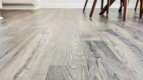 Sleek, gray-toned, wood-look flooring that spans the hallways and primary entertaining space.