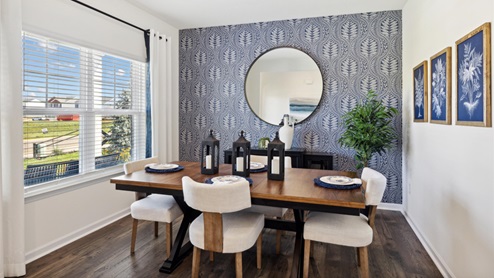 Formal dining room with a wallpaper-clad focal wall behind a wooden table surrounded by four upholstered dining chairs.