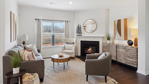 Living room with sofa, chair, fireplace, and console.