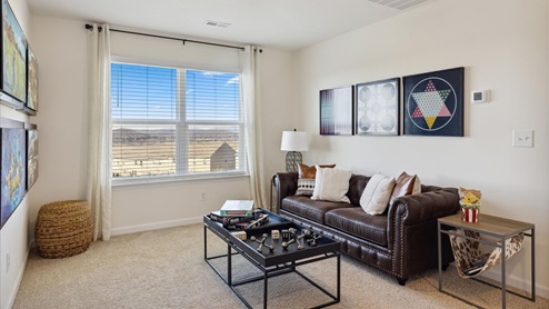 loft area brown chesterfield sofa on the right with end tables on each side wall art above and black coffee table