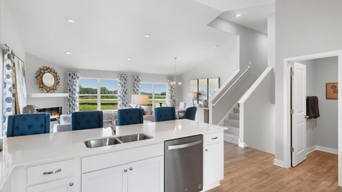 White kitchen cabinets, quartz countertops and stainless appliances.
