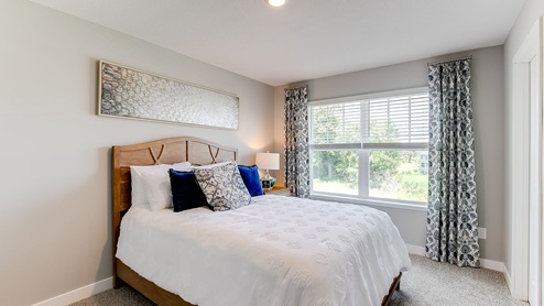 Carpeted secondary bedroom with walk-in closet.