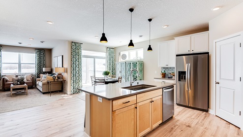 Kitchen island with brown cabinets and stainless steel appliances.