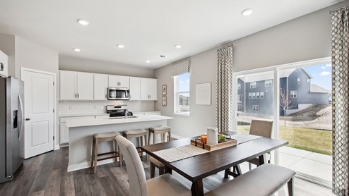 View of dinette and kitchen areas on open concept main level.