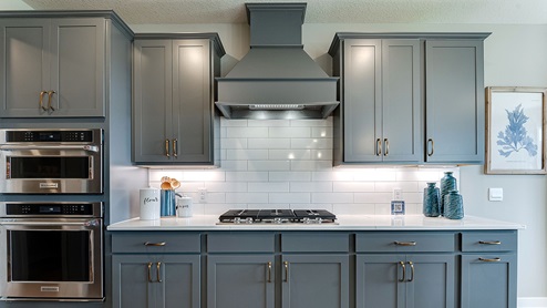 Straight on view of gas cooktop, single wall oven, and wood hood.
