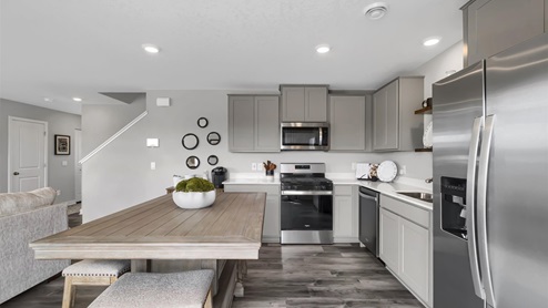 Kitchen with gray cabinets and quartz countertops.