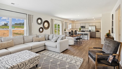 Interior living room open to kitchen and large windows