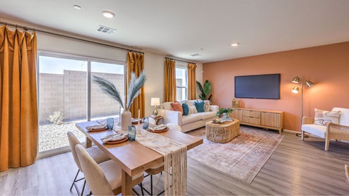 The Tribute Trails 1334 model Dining Room adjacent to the kitchen with a table and a sliding door to the backyard.
