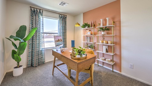 The Office/Bedroom Three option in our Spectrum Trails 1334 model with carpet flooring, a sliding closet, and a window, furnished with a desk and chair.