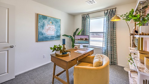 The Office/Bedroom Three option in our Spectrum Trails 1334 model with carpet flooring, a sliding closet, and a window, furnished with a desk and chair.