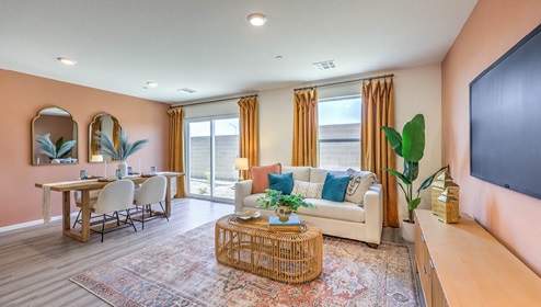 The Spectrum Trails 1334 Plan open concept Great Room with LVP panel flooring, two windows, and a sliding door to the backyard.