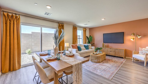 The Spectrum Trails 1334 Plan open concept Great Room with LVP panel flooring, two windows, and a sliding door to the backyard.